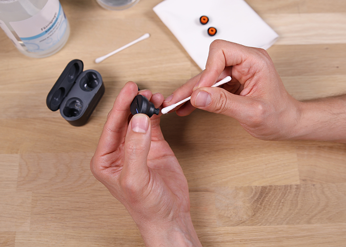 Cerumen Grid des In-Ears mit einem Wattestäbchen reinigen